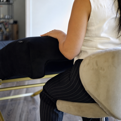 Postura ergonómica da profissional junto à Lash Bed FB Comfy preta com estrutura original