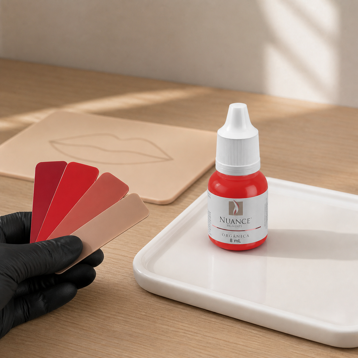 Nuance Pigmento Orgânico Granada 8 ml — frasco fechado numa mesa de seleção cromática com amostras e pele sintética; SKU NO53026