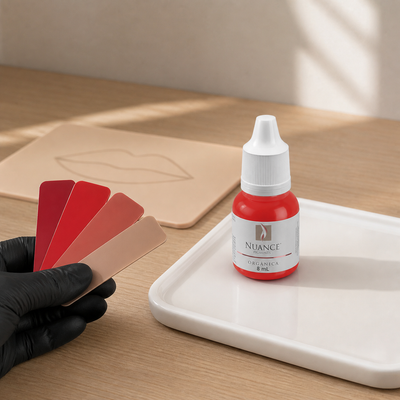 Nuance Pigmento Orgânico Granada 8 ml — frasco fechado numa mesa de seleção cromática com amostras e pele sintética; SKU NO53026